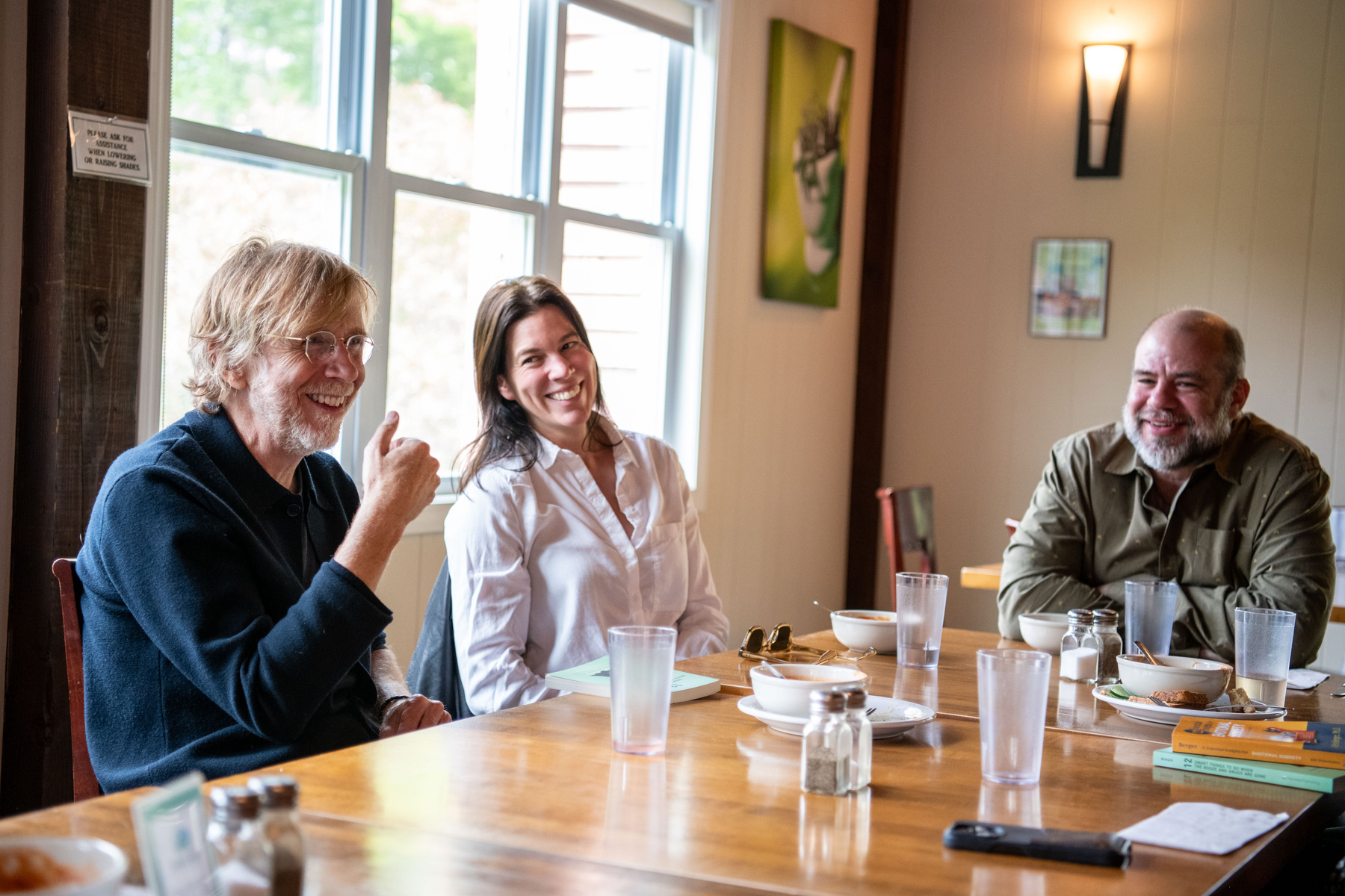 Two people sharing a conversation at a table, from Divided Sky’s supplied materials